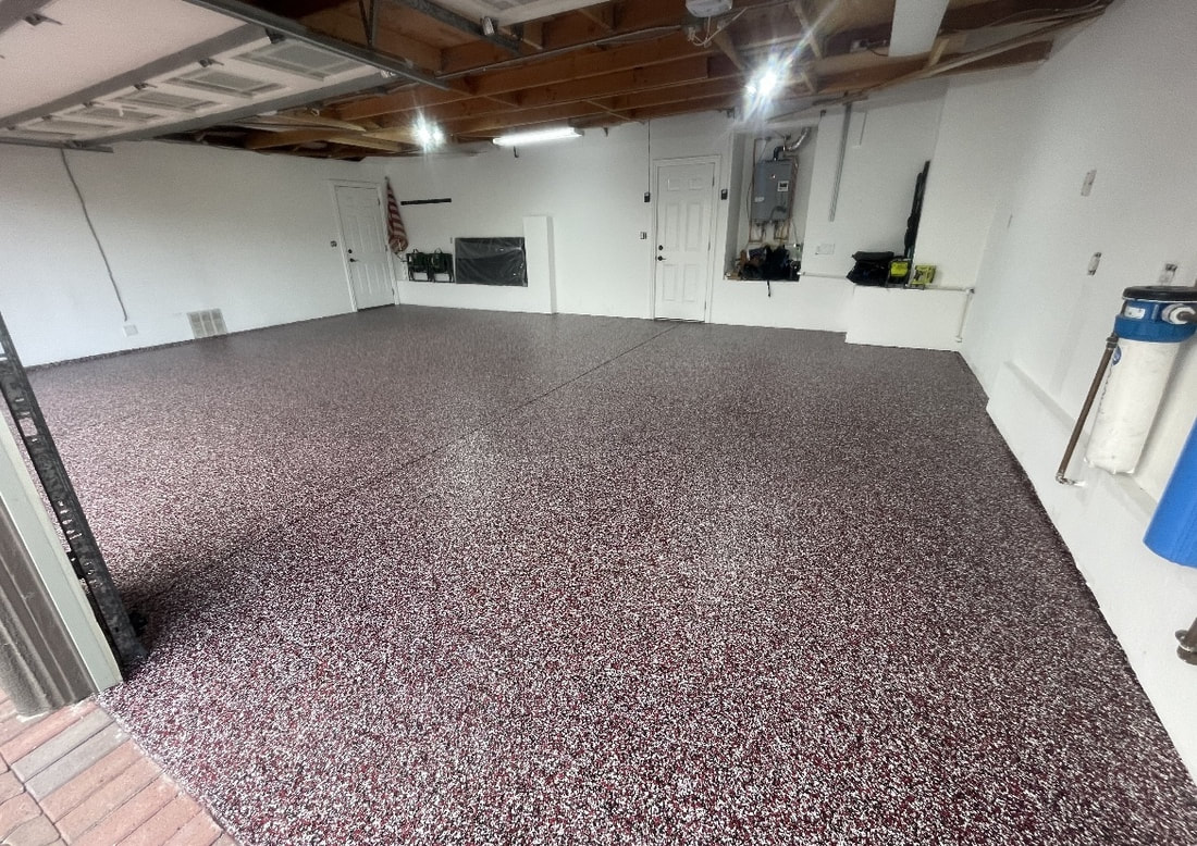 Two-car garage finished in a maroon and white epoxy flake coating