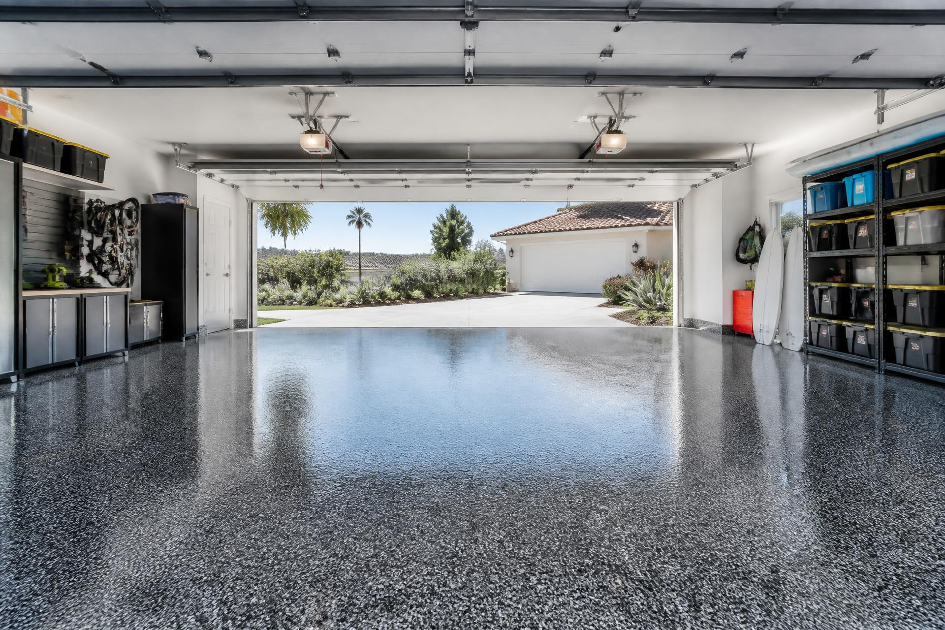 Residential garage with a glossy gray epoxy flake floor